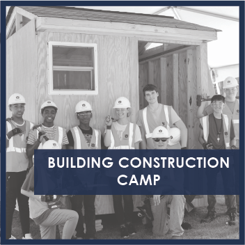 Group of young people in front of small building under construction